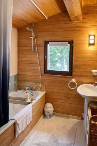 a bathroom with a bath tub and a sink at The chalet of time in Eyne
