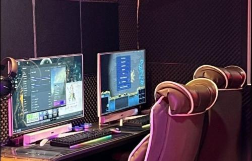a desk with two computer monitors and a chair at Dalbit Sori Hotel Jeonju in Jeonju