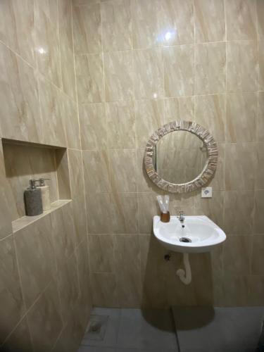 a bathroom with a sink and a mirror at Ramaiin guest house in Nusa Dua