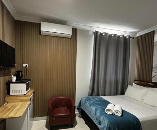 a hotel room with a bed and a chair at Perth City Motel in Perth