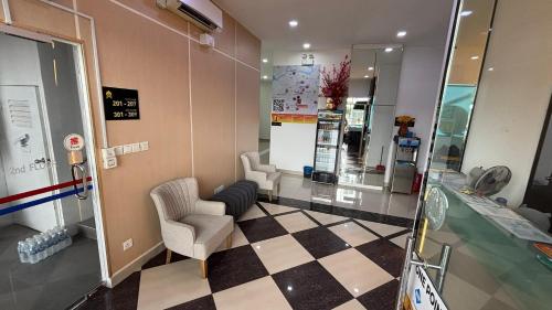 a waiting room with two chairs and a checkerboard floor at One Point Hotel @ Airport (Kuching) in Kuching