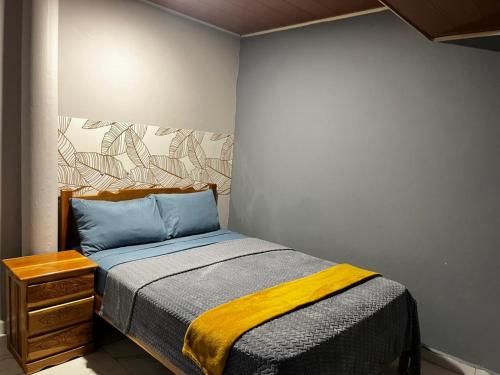 a bedroom with a bed with a yellow blanket at Isabella Hostel and Pool in Alto Boquete