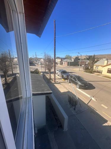 a balcony with a bench and a car on a street at Tu Espacio en Rada in Rada Tilly