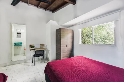 a bedroom with a pink bed and a desk at Living Hotel in Medellín
