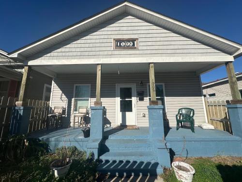 a house with a porch with a sign on it at Chestnut Hostel in Wilmington
