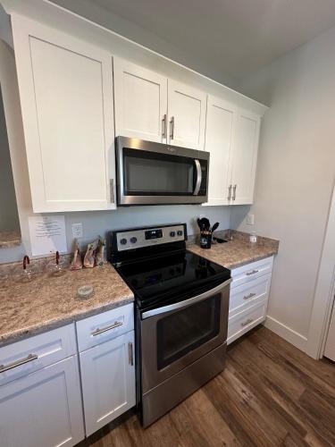 a kitchen with a stove and a microwave at Chestnut Hostel in Wilmington