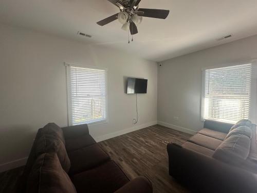 a living room with a couch and a ceiling fan at Chestnut Hostel in Wilmington