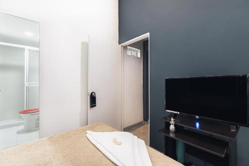 a living room with a flat screen tv and a table at Living Hotel in Medellín