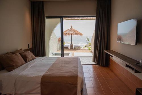 a bedroom with a bed and a view of the beach at Meraki Oasis Hotel in Mui Ne