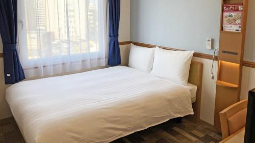 a small bed in a room with a window at Toyoko Inn Toyama eki Shinkansen guchi No 1 in Toyama