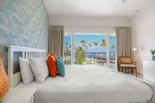 a bedroom with a large bed with a view of the ocean at Destination Jelly Playa Coral Condo in Punta Cana