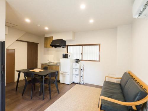 a kitchen and a living room with a table and a couch at 桜花上水 in Tokyo