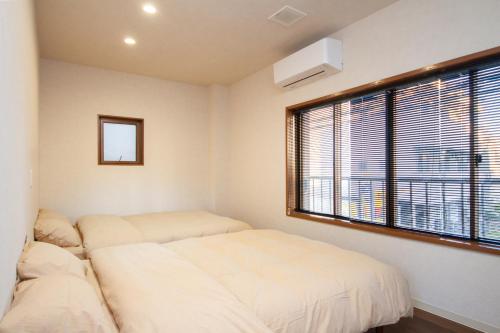 two beds in a room with a window at 桜花上水 in Tokyo