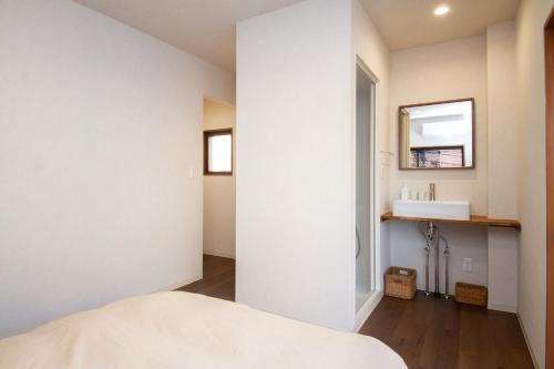 a bedroom with a bed and a mirror and a sink at 桜花上水 in Tokyo