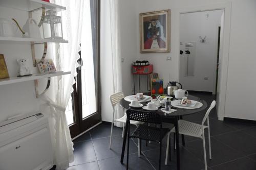 a dining room with a black table and chairs at Maria Vittoria Charming Rooms and Apartments in Brindisi