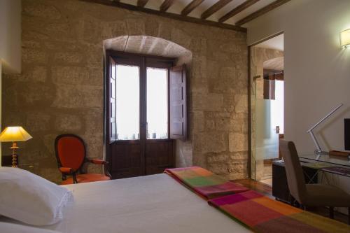 a bedroom with a bed and a window and a desk at La Capellanía in San Asensio
