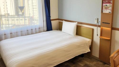 a small bed in a room with a window at Toyoko Inn Toyama eki Shinkansen guchi No 1 in Toyama