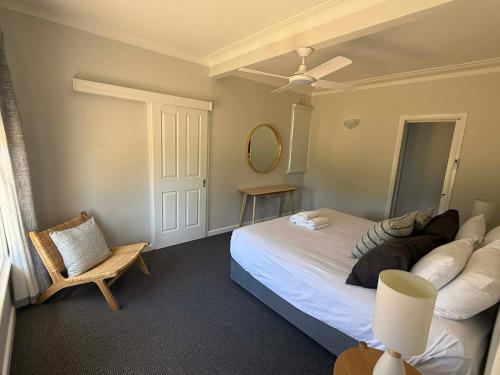 a bedroom with a large bed and a chair at Units on Robertson in Mudgee