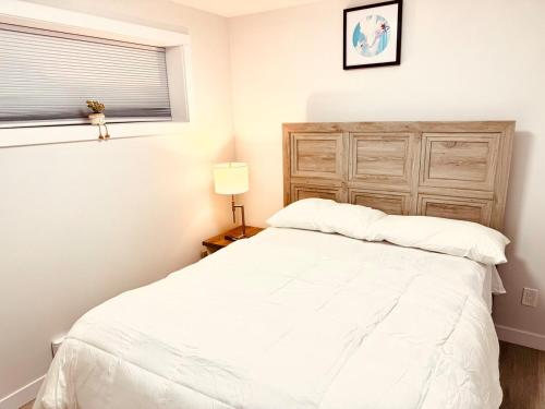 a bedroom with a white bed and a window at Maple Nest in Regina