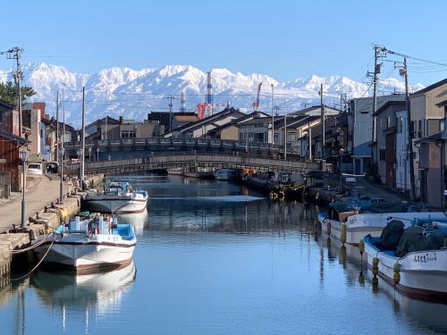 two boats are docked in a river with a bridge at MINKA Riverside Villas in Shimminato
