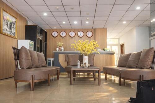 a waiting room with two chairs and a table and clocks at M&M Việt Tiệp Hotel in Dĩ An