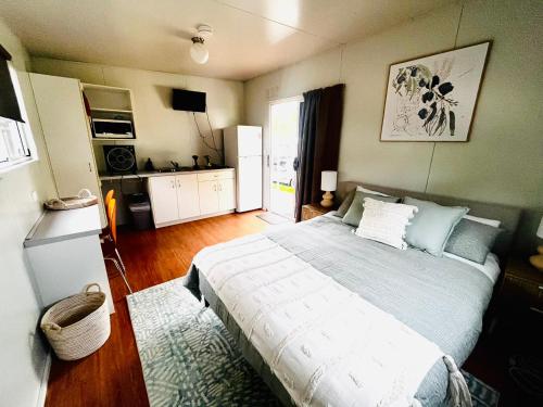 a bedroom with a large bed and a kitchen at Country Style Holiday Park in Stanthorpe