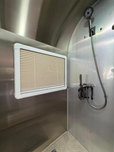 a bathroom with a shower with a window and a shower at One Life Glamping Caravan Rawson in Rawson