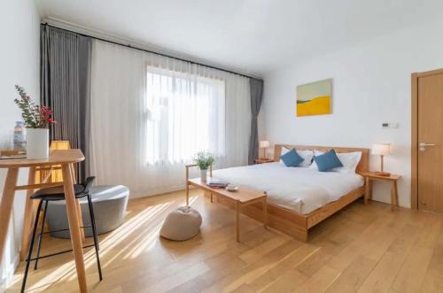 a bedroom with a bed and a table and a desk at TRANQUIL HOUSE in Lhasa