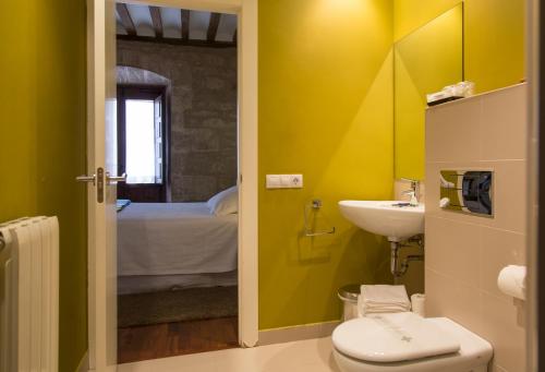 a yellow bathroom with a toilet and a sink at La Capellanía in San Asensio