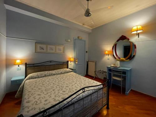 a bedroom with a bed and a mirror and a table at Lilium Boutique Hotel in Rome