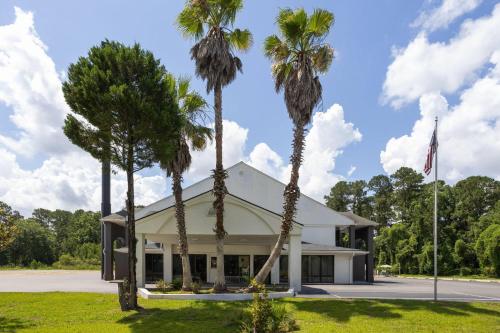 a building with palm trees in front of it at Days Inn by Wyndham Hardeeville Near Hilton Head in Hardeeville