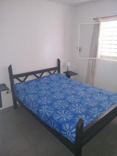 a bedroom with a bed with a blue comforter at Cabañas Sucot in Tanti