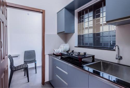 a kitchen with a sink and a counter top at Dune Homestay in Alleppey