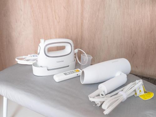a toaster and other appliances sitting on a table at Fuukanto Kinshicho BNB in Tokyo