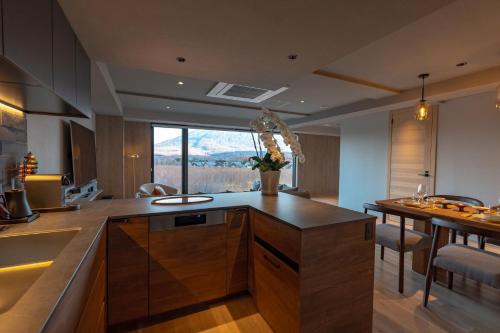 a kitchen with a counter and a dining table at The 1898 Niseko in Kutchan