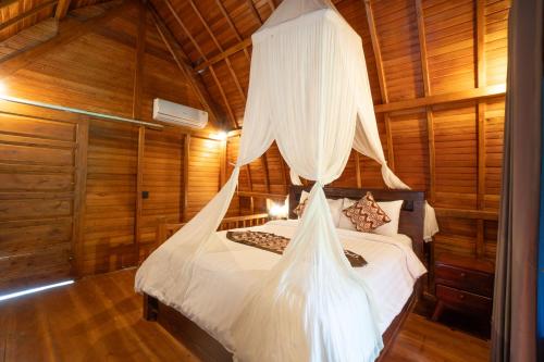 a bedroom with a bed with mosquito netting at Jungle Forest Villa Ubud by The Travel Ubud Bali in Ubud