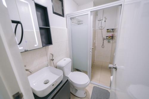 a small bathroom with a toilet and a shower at Instaworthy 1BR unit at Royal Oceancrest Mactan in Mactan Island