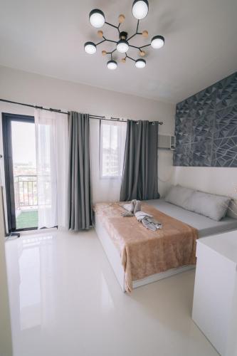 a bedroom with a large bed and a chandelier at Instaworthy 1BR unit at Royal Oceancrest Mactan in Mactan Island