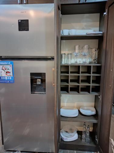 a refrigerator with plates and dishes in it at RoofTop in Kollpa