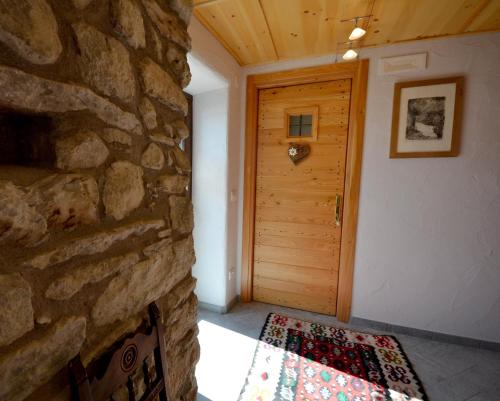 a room with a stone wall and a wooden door at Maison Du-Noyer Chambres et Tables d'Hotes in Aosta