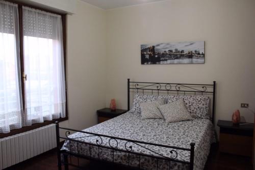 1 dormitorio con 1 cama y 2 ventanas en Appartamento Le Magnolie, en Trezzano sul Naviglio