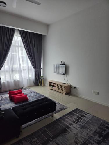a living room with a black bed and red pillows at D'BROGA HILL Homestay in Kampong Solok