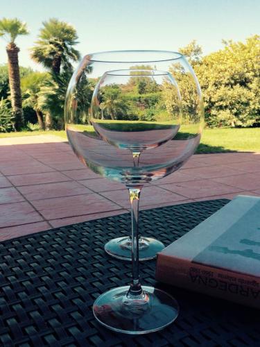 a glass of wine sitting on top of a table at A Casa Di Angela B&B in Carbonia
