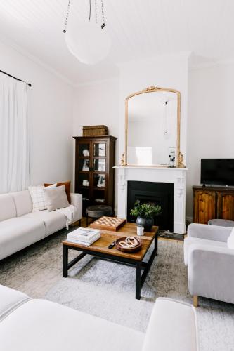 a living room with a coffee table and a mirror at Oakview Country House Maffra in Maffra