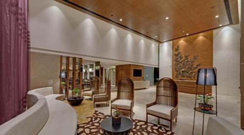 a lobby with chairs and a couch and a television at The Fern - Goregaon in Mumbai