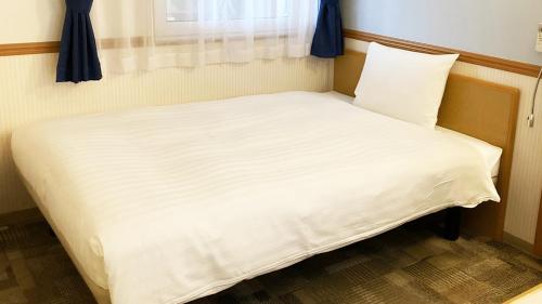a small bed in a room with a window at Toyoko Inn Toyama eki Shinkansen guchi No 1 in Toyama