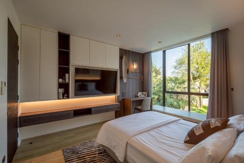 a bedroom with a large bed and a large window at Cicada Estate in Ban Mae Pu Kha