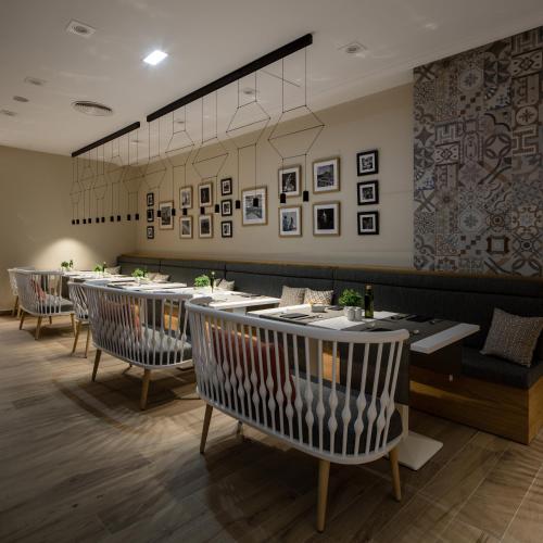 a restaurant with a row of tables and chairs at Catalonia Giralda in Seville