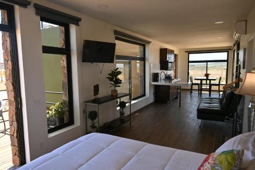 a bedroom with a bed and a living room at Flor de Garambullo, Valle de Guadalupe in Valle de Guadalupe