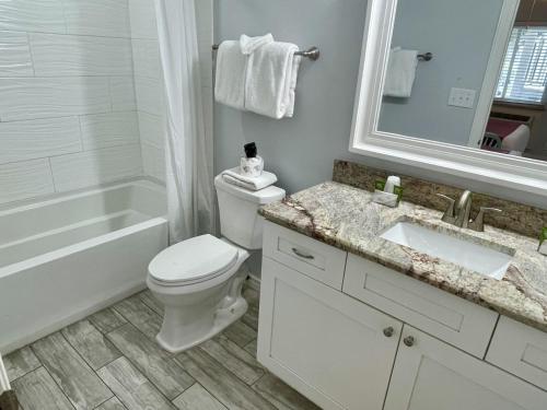 a bathroom with a toilet and a tub and a sink at Beachgate Condo Suites and Hotel 218 condo in Port Aransas